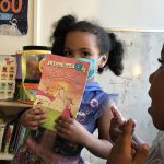 little girl with book from Community Education Partnerships