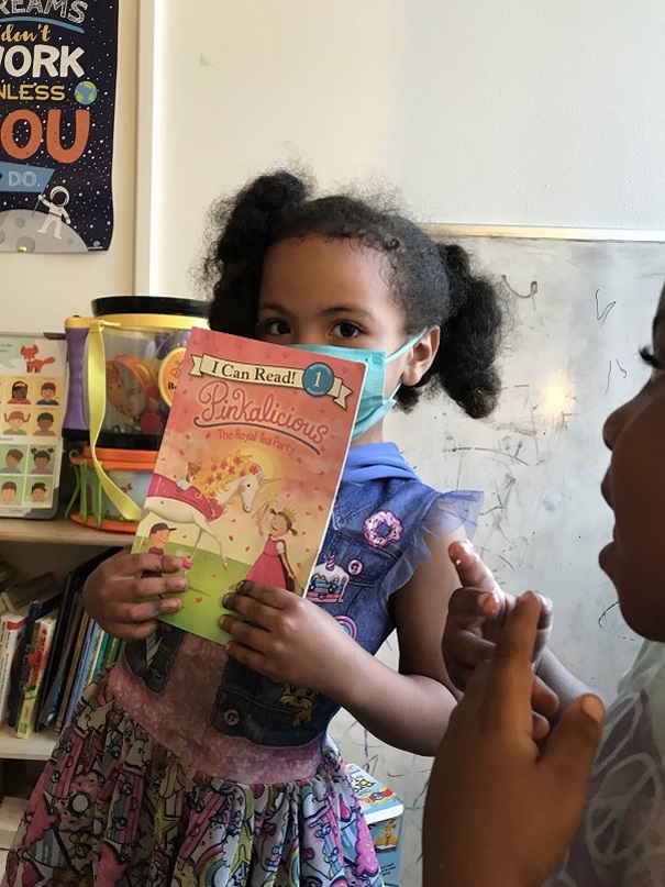little girl with book from Community Education Partnerships