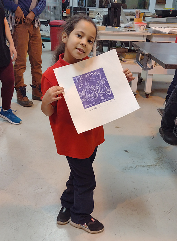 Little scholar holds up a picture at Future Urban Leaders