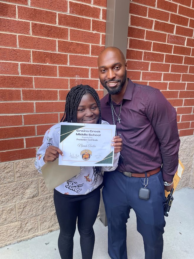 moore buddies mentoring mentee proudly holds diploma alongside smiling mentor