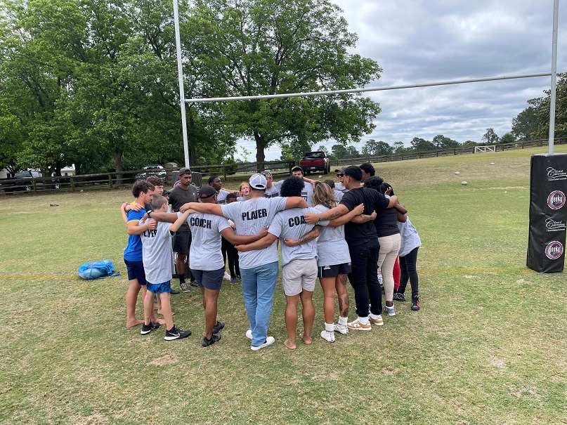 moore buddies mentoring huddle on field before game 