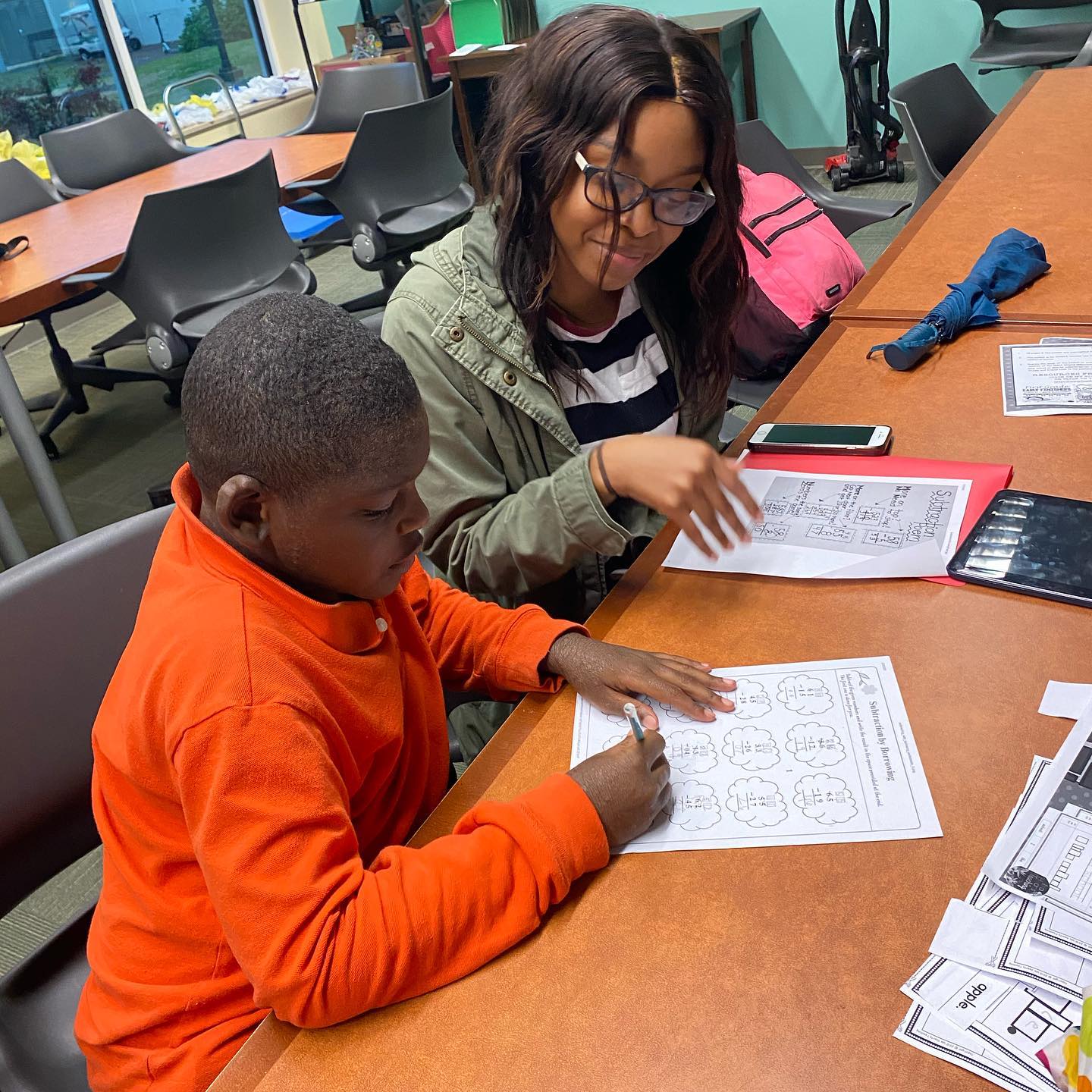 smiling tutor with sweet faced african american boy w.e. move tutoring