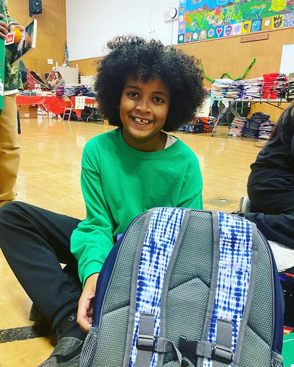 Youngster with new backpack from Sydney Paige Foundation