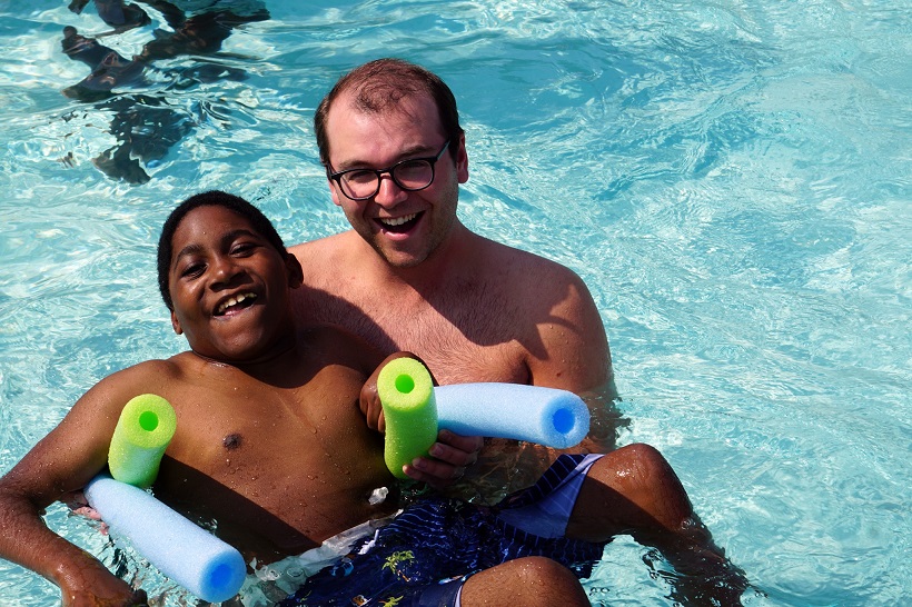 Camp Cranium boy with volunteer, pool floaties