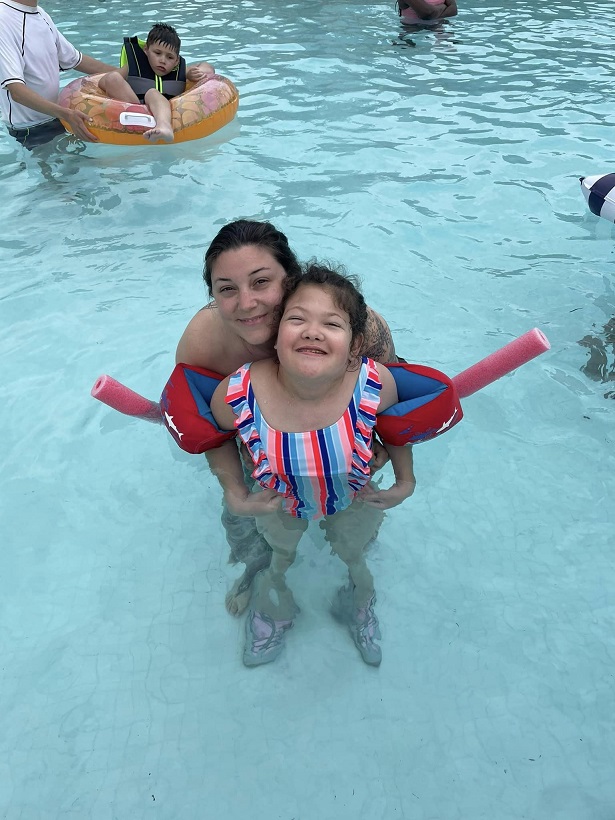 camper swims with volunteer, pool, floaties