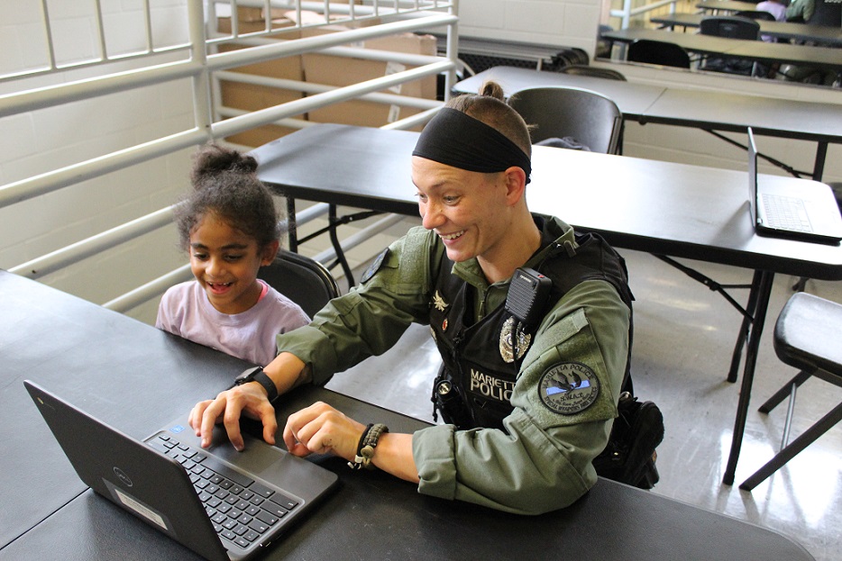 smiling female cop works with young black girl Marietta PAL