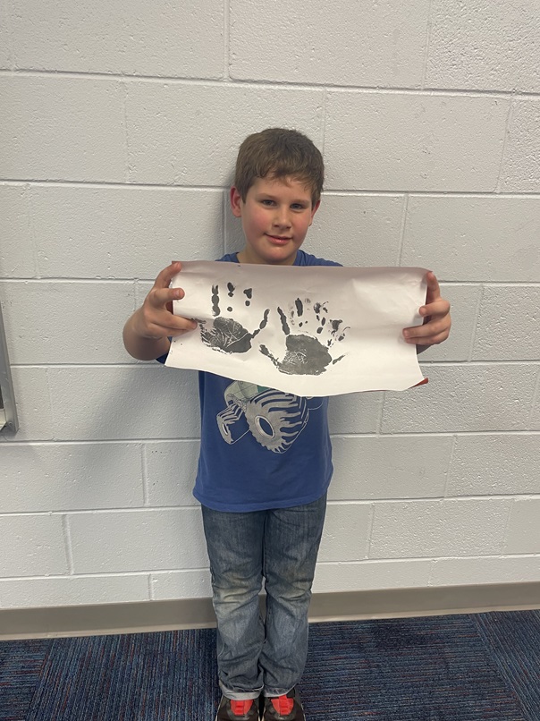 Boy shows handprint picture ECYEC