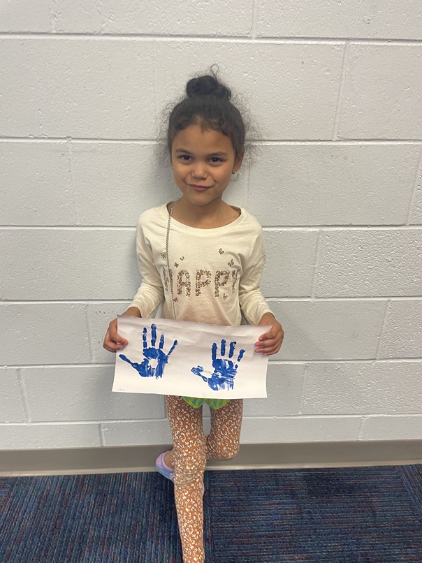 Girl shows handprint picture ECYEC