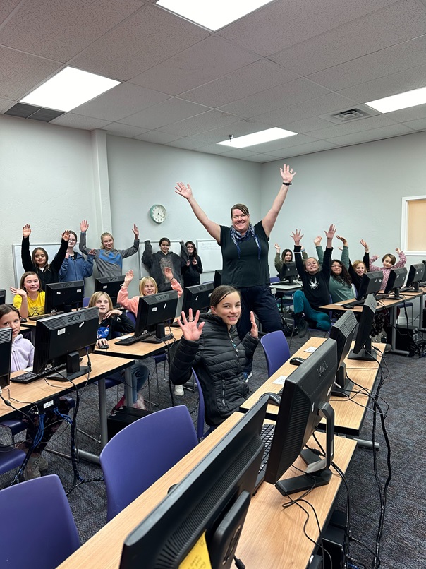 Code Girls United participants excitedly wave hands in the air