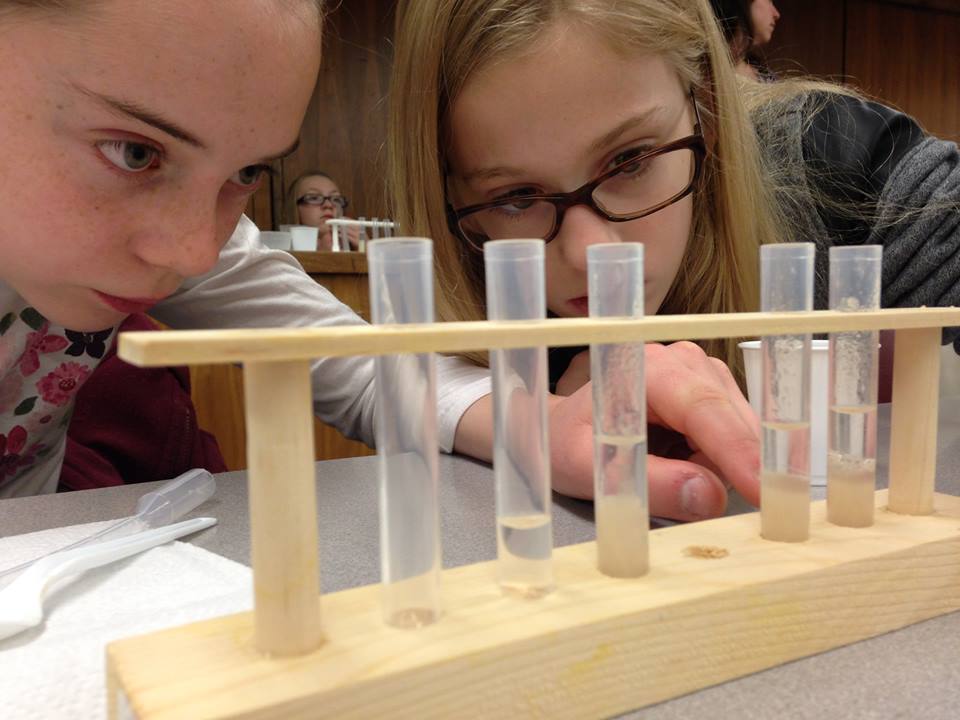 Girls look at test tubes Cool Science Company