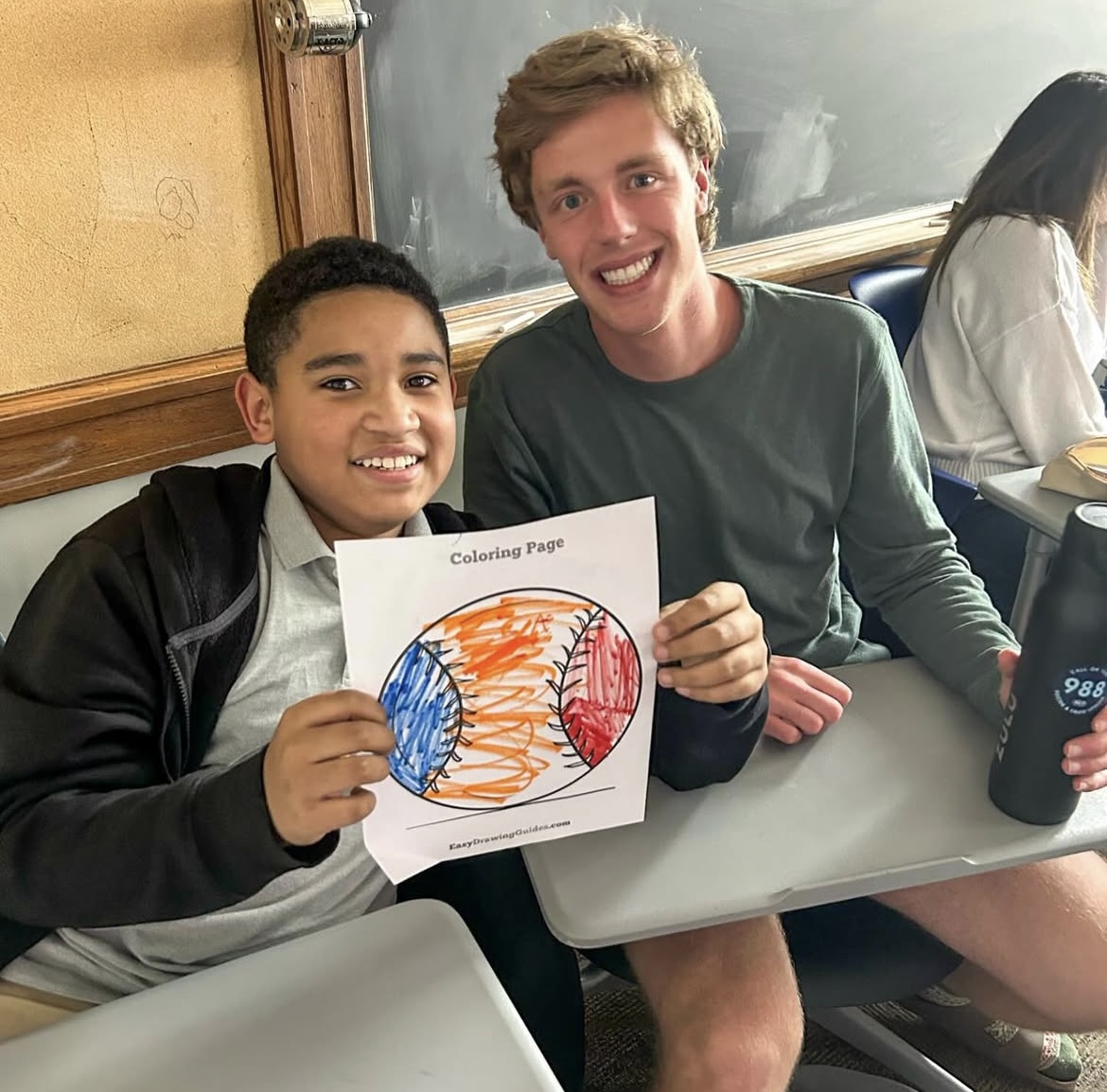 College Mentors for kids male mentor with mentee who holds drawing