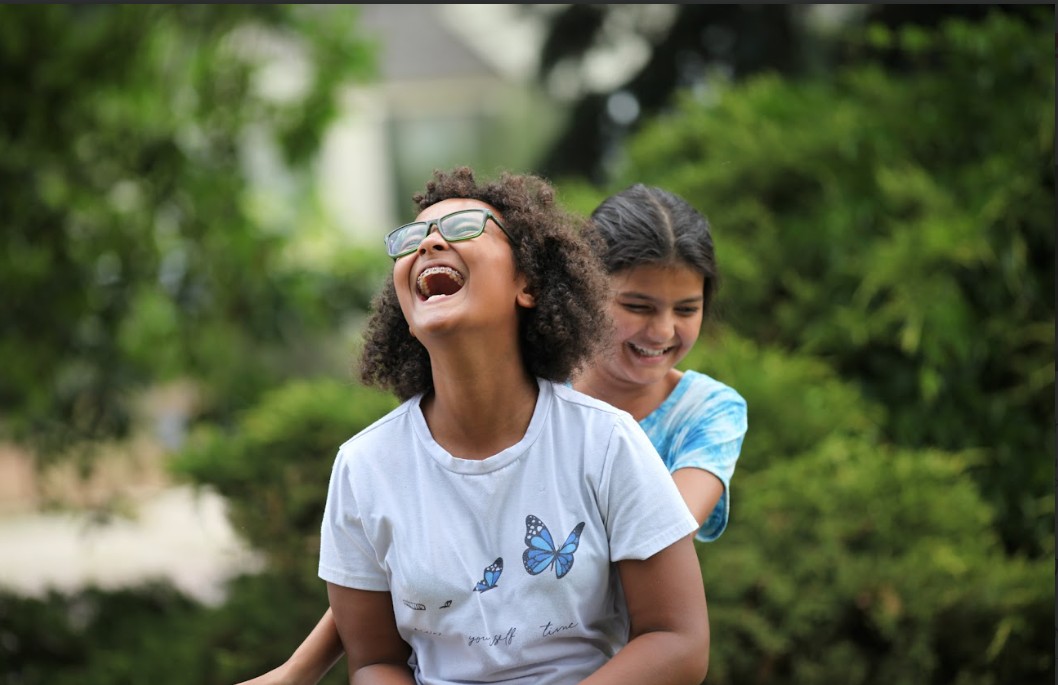 2 laughing girls outdoors peak education