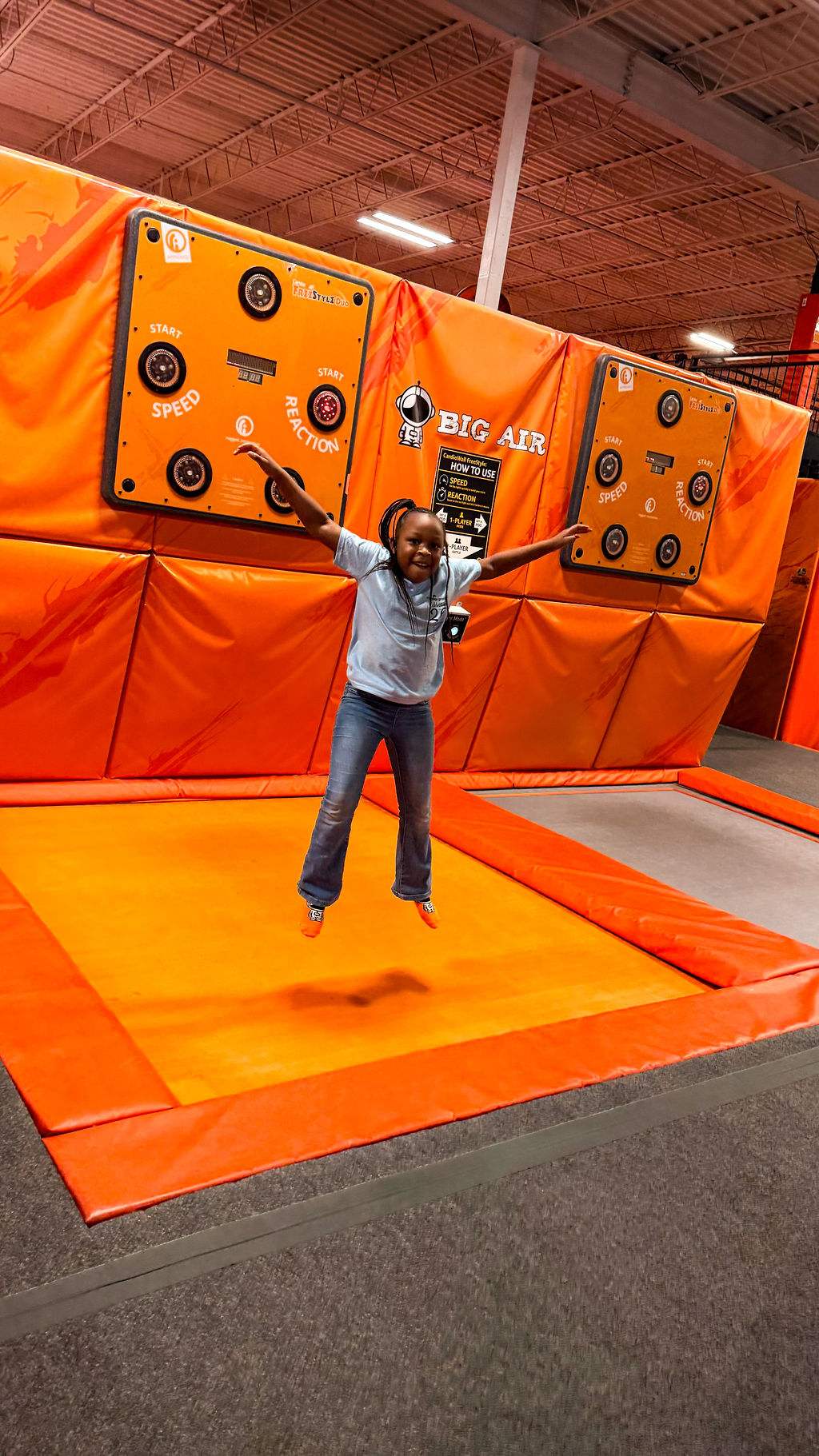 Smiling African American girl jumps on trampoline during field trip with The Village Group