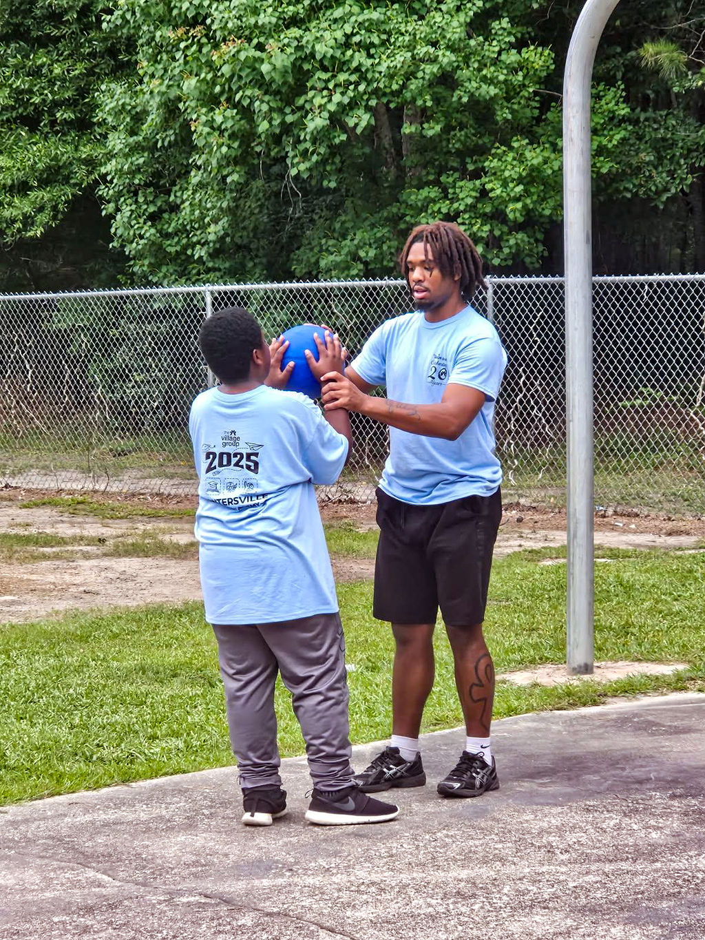Young boy gets help with learning basketball moves