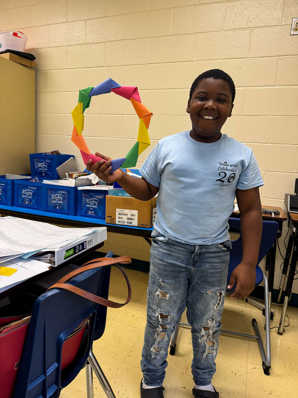 The Village Group, smiling African American boy holds hand-crafted rainbow circle