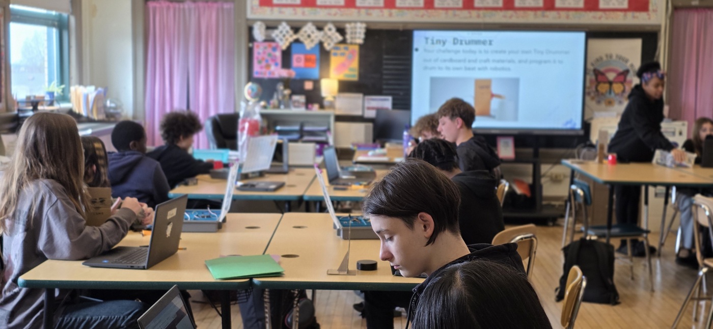 Learning together: Students collaborate during an in-school STEM Coding Lab class, combining digital tools with guided instruction.