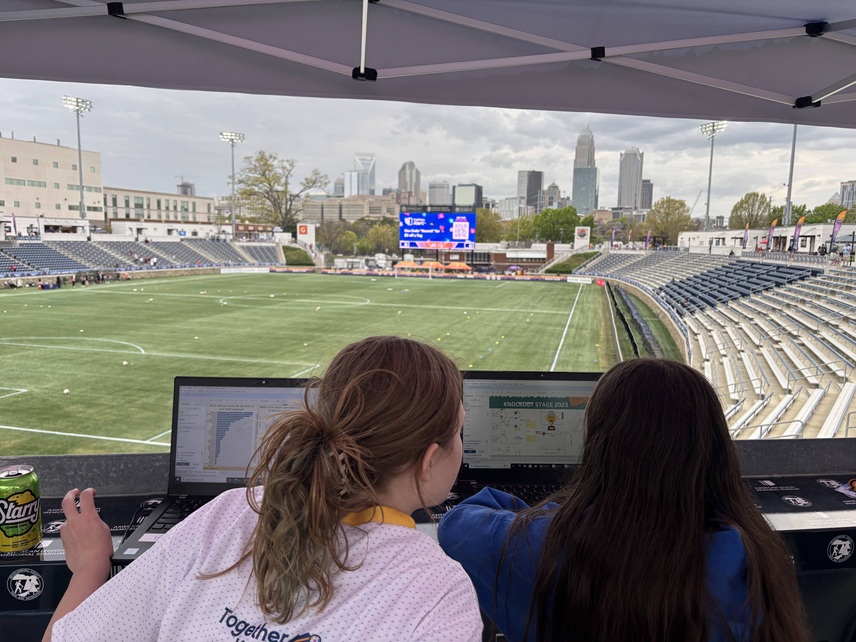 Girls at sporting event with computers, STEM learning experience