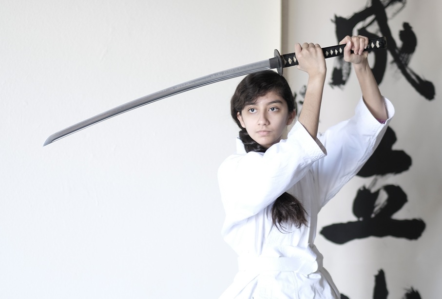 Budo Accelerator student practicing sword technique in a dojo as part of martial arts leadership training.