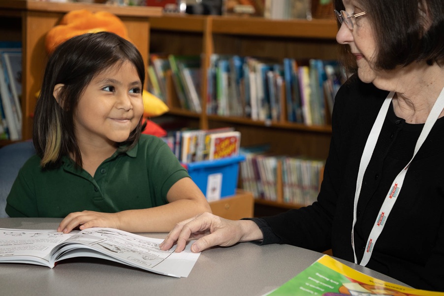 AR Kids Read smiling girl works with tutor