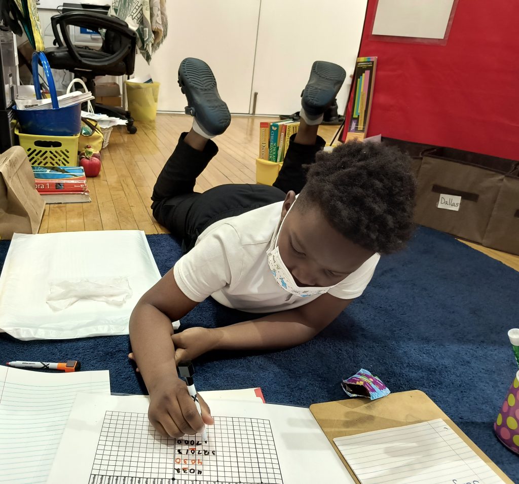 Young student practicing math problems during one-on-one tutoring session with Inner City Youth Tutoring in St. Louis