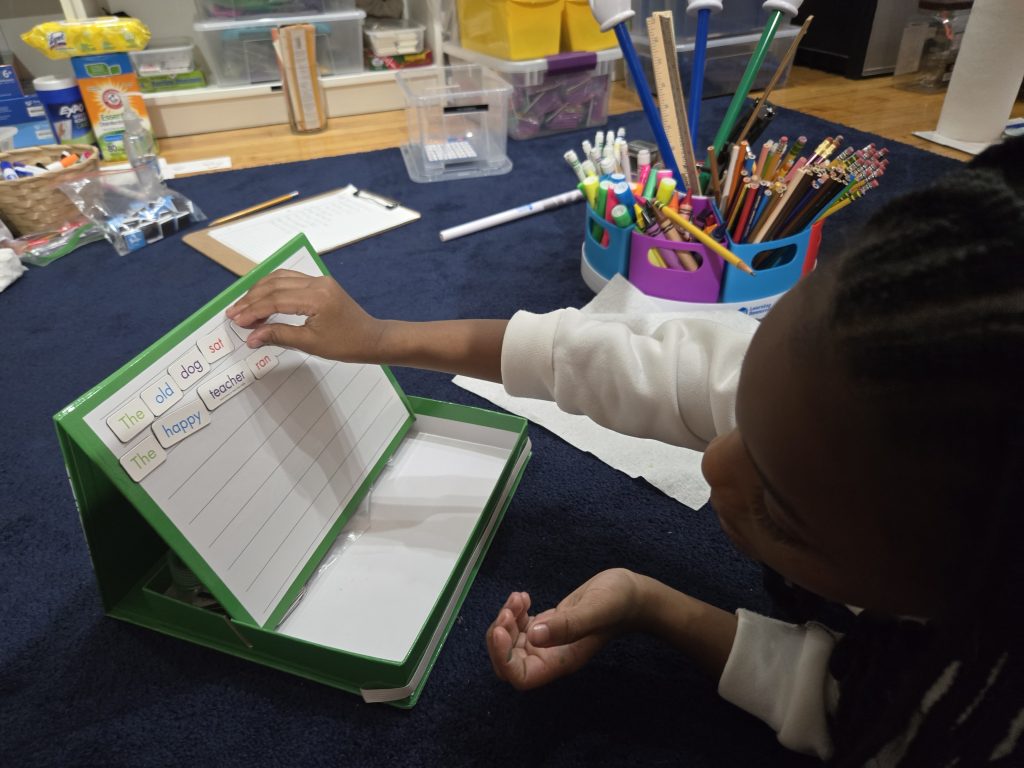 Elementary student building sentences with word tiles during personalized language arts tutoring