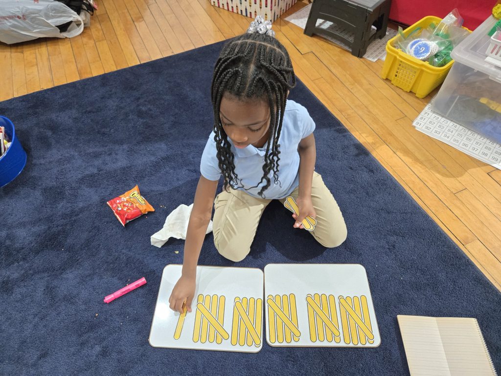 Young student using hands-on math tools to learn counting and number concepts in tutoring program