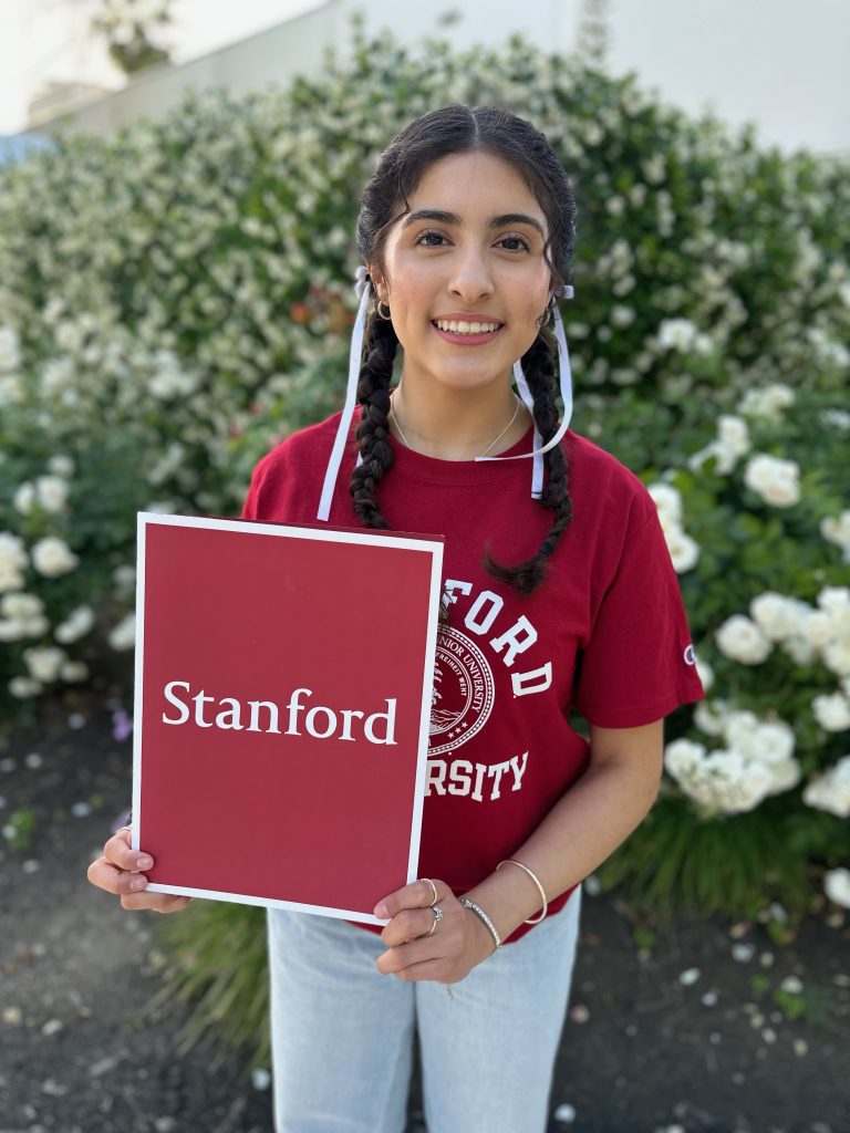 Neighborhood Degree student holds Stanford sign