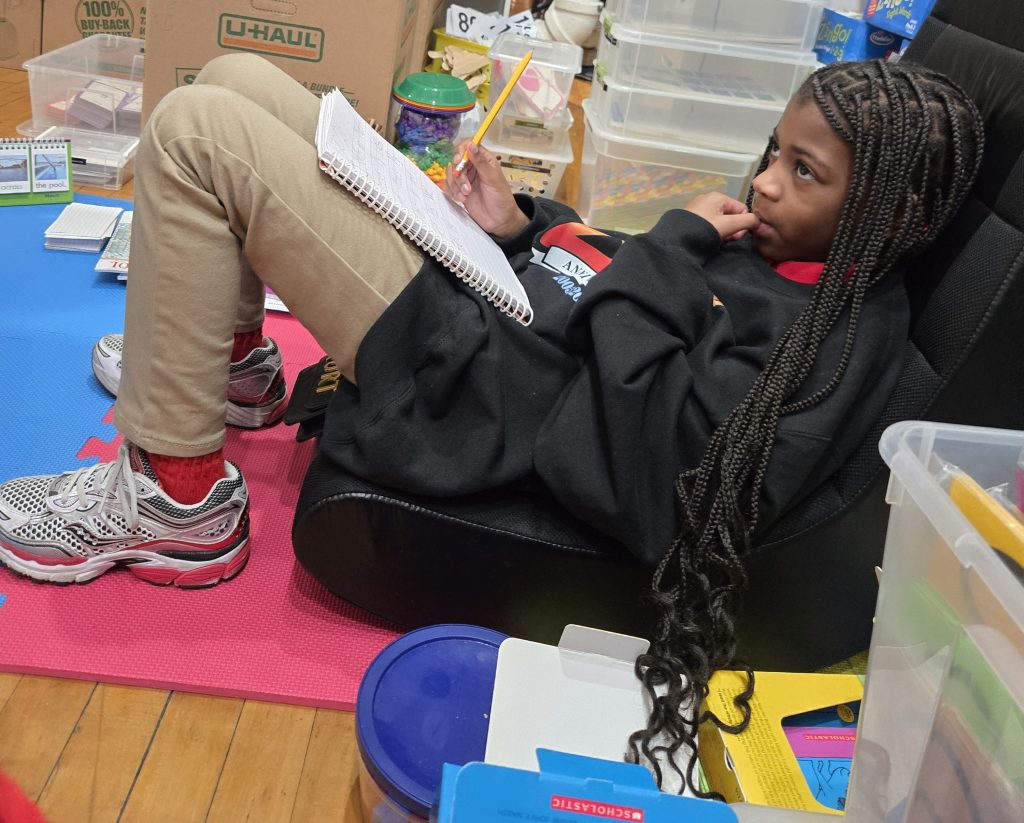 Student focused on schoolwork during one-on-one tutoring session at community learning space