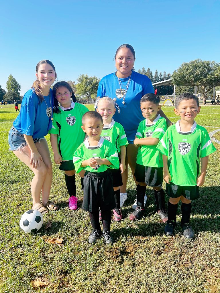 children in soccer uniforms with coaches Neighborhood Degree