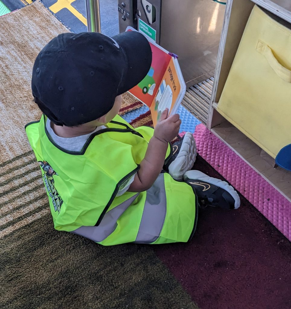 Young child reading inside The Free Book Buggie mobile library