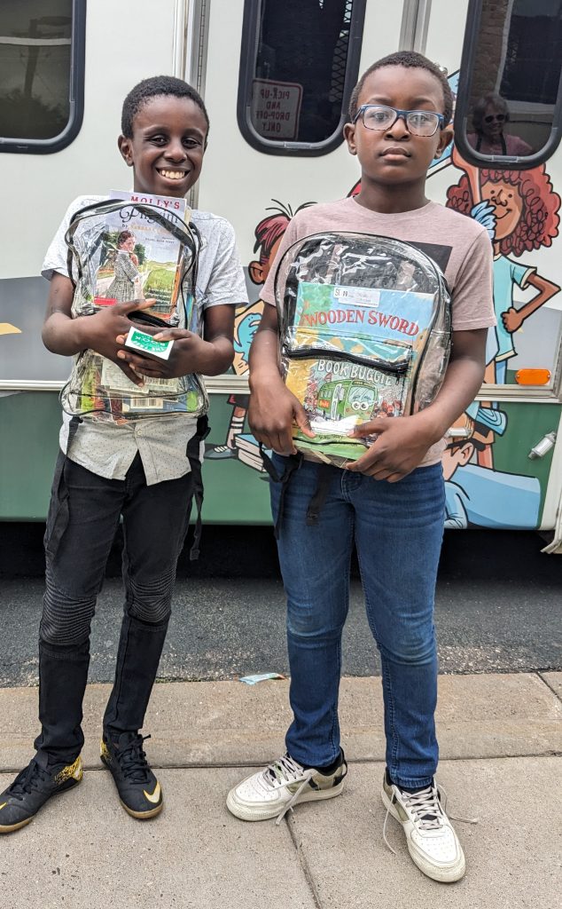 Children holding free books outside The Free Book Buggie