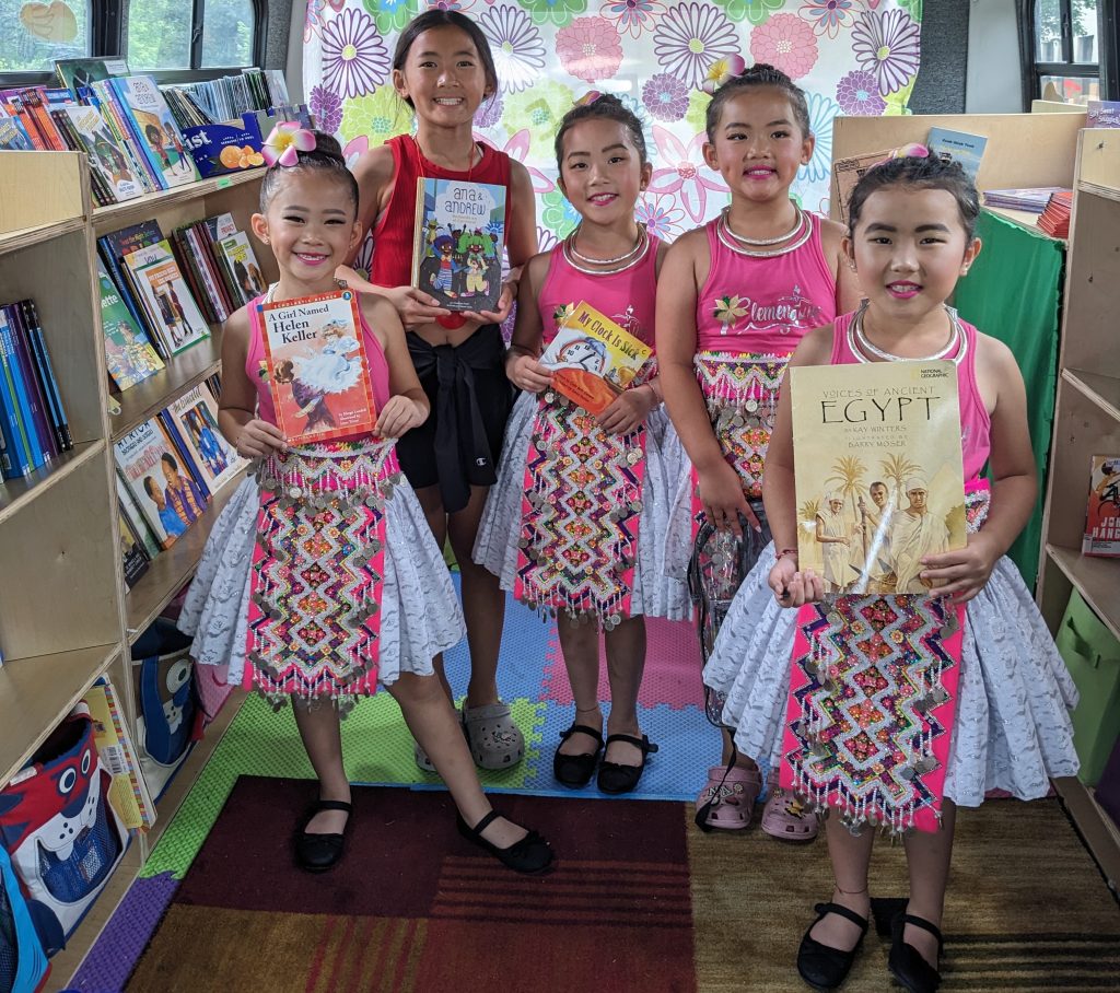 Young readers showing books at The Free Book Buggie community event