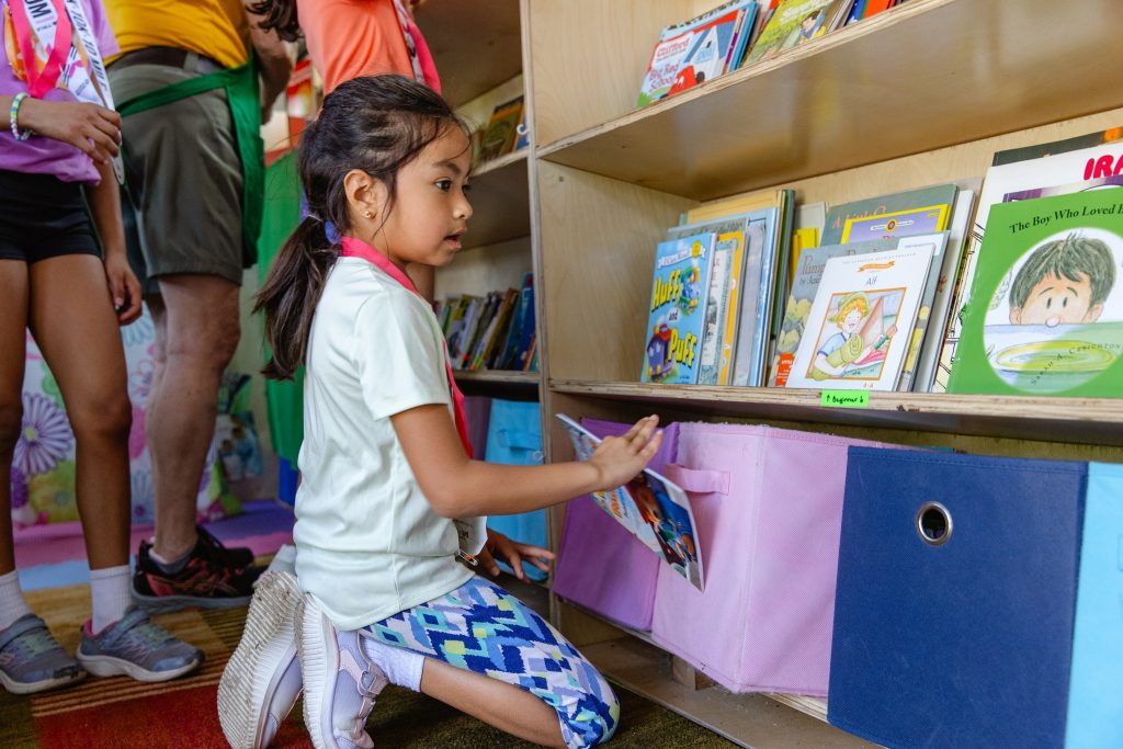 Child choosing a book inside The Free Book Buggie mobile library