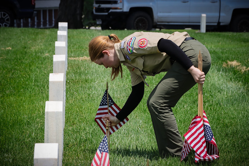 Greater St. Louis Area Scouting female scout places flag in front of veteran's grave