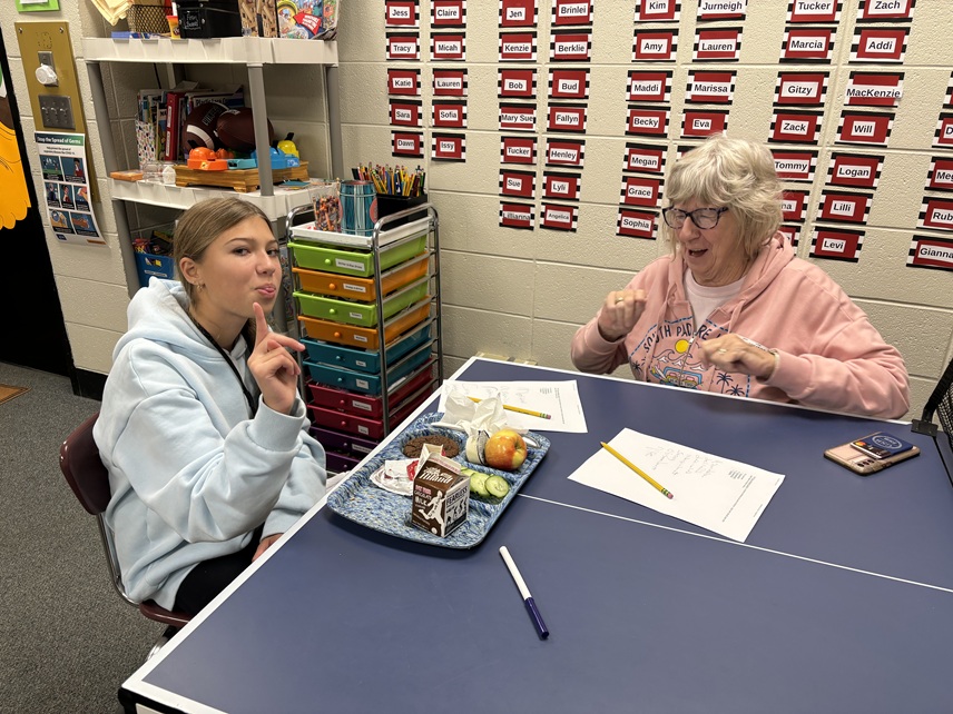 lunchtime mentoring elderly woman girl sticks tongue out